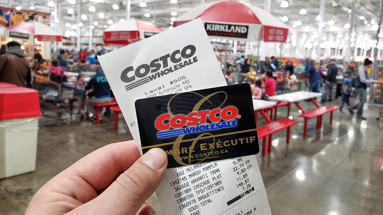 hand holding Costco receipt and card