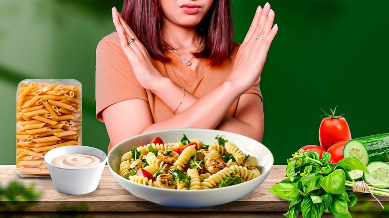 Woman sitting behind pasta salad